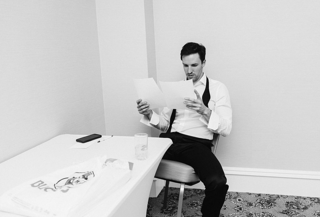 Groom reading note from bride before Houstonian wedding ceremony 