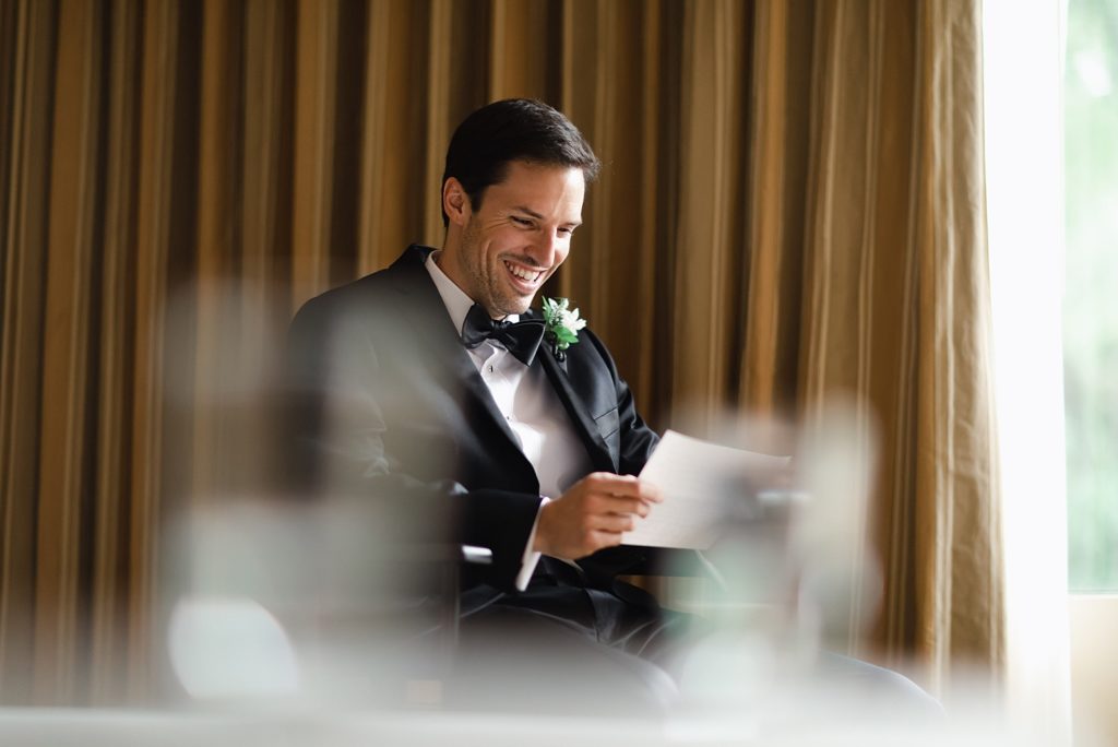 Groom smiling as he reads letter from his Bride in the Houstonian