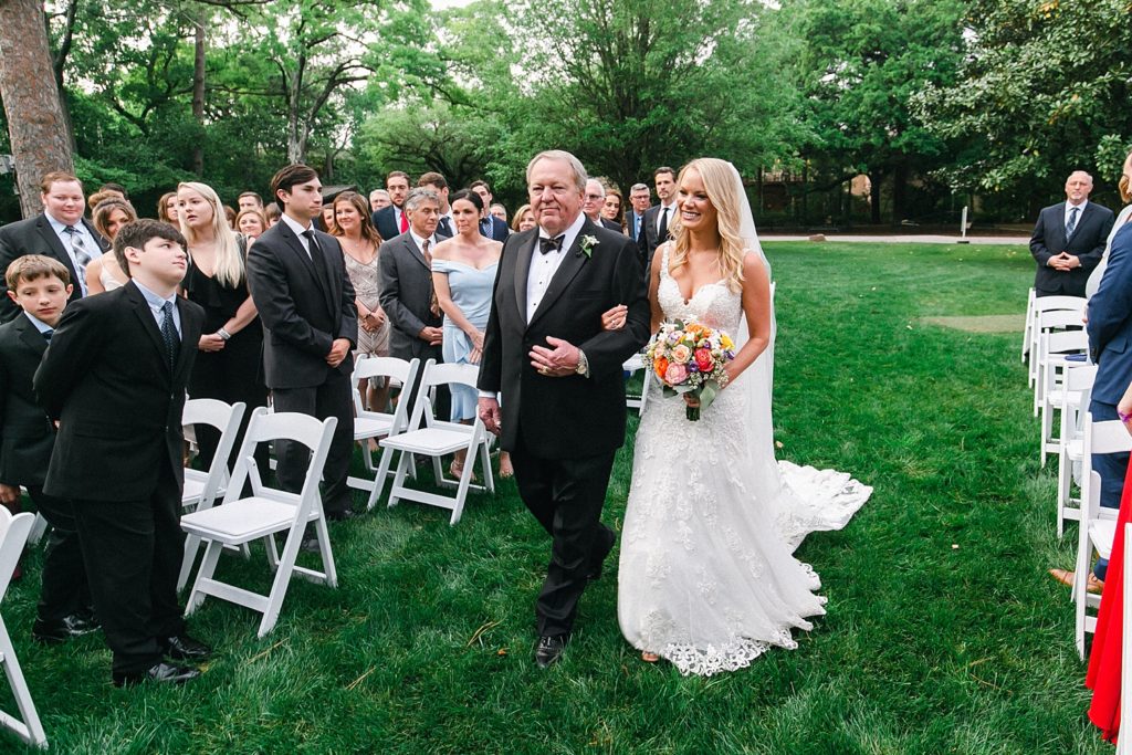 Bride walking down the aisle in outdoor Houstonian wedding ceremony 