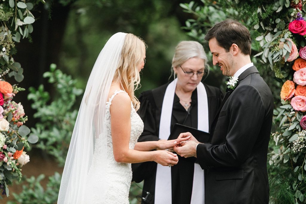 Ring exchange at outdoor wedding ceremony at the Houstonian