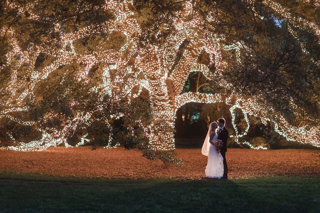 Stunning Bride and Groom portrait under a lit tree after their wedding ceremony at the Houstonian