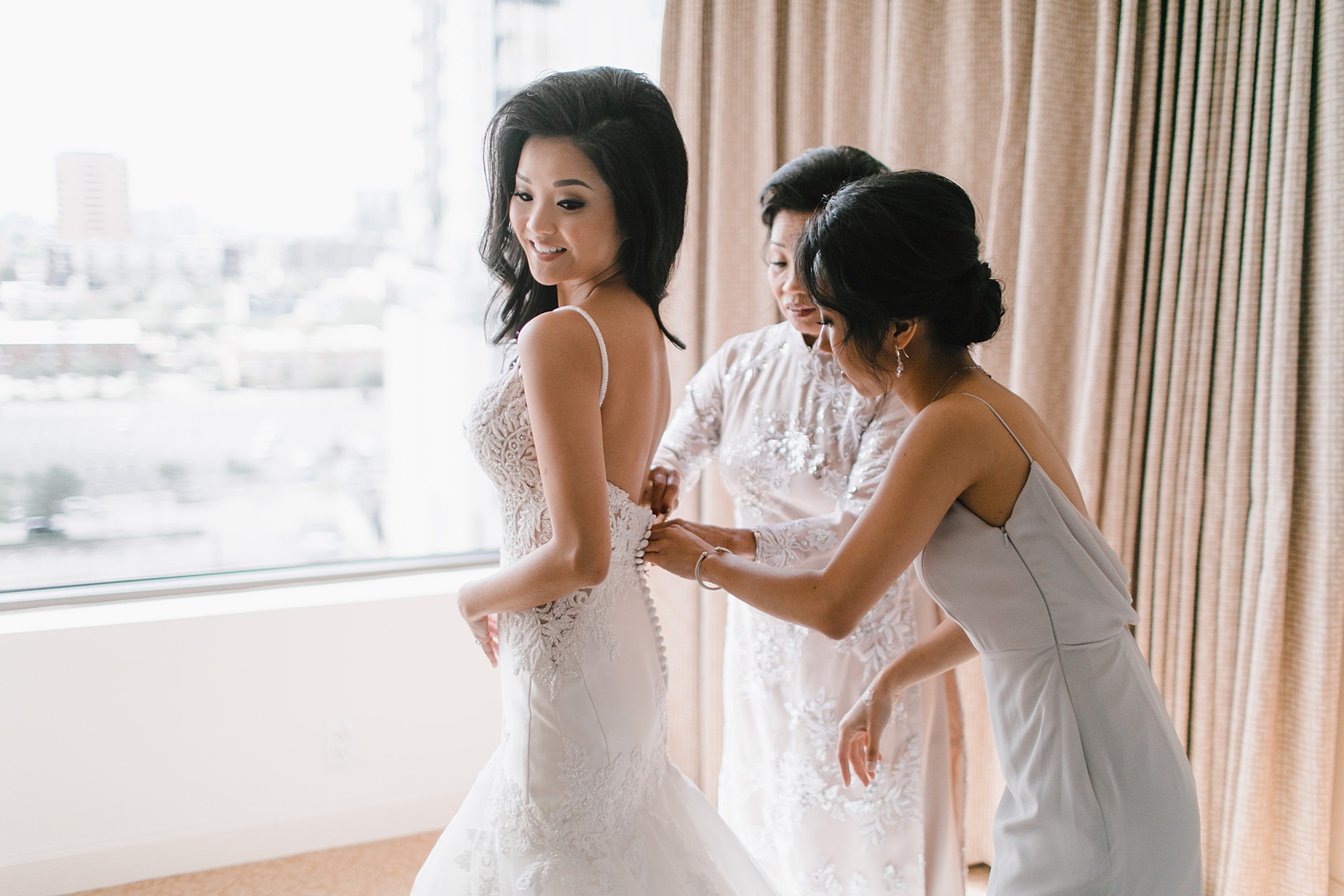 Bride helped into her dress before her ceremony 