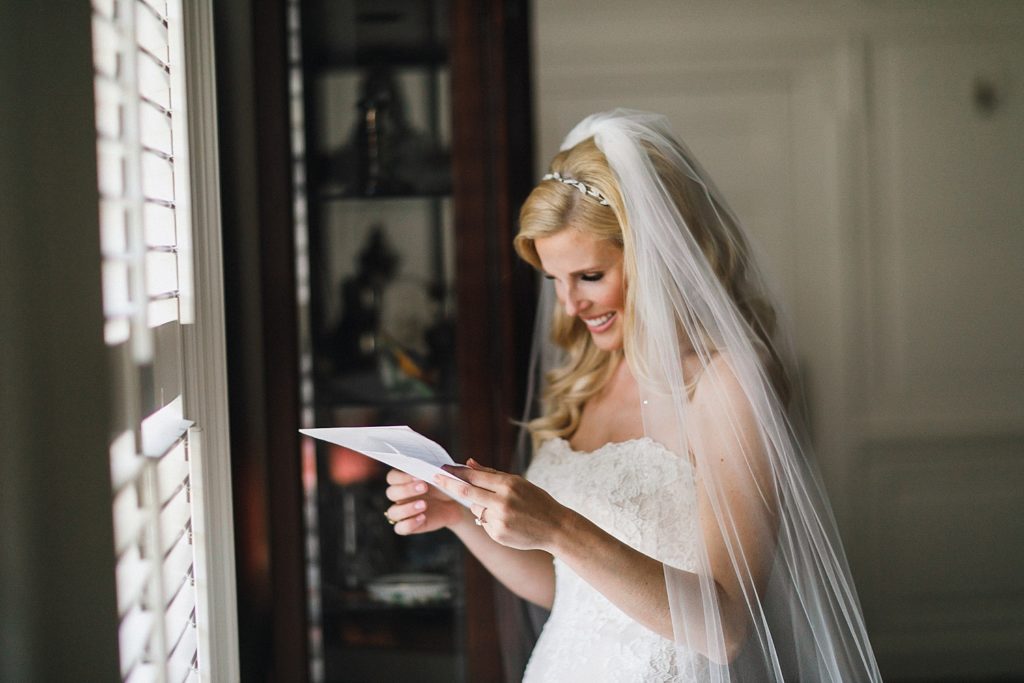 bride reading letter from her groom while standing in the omni hotel room