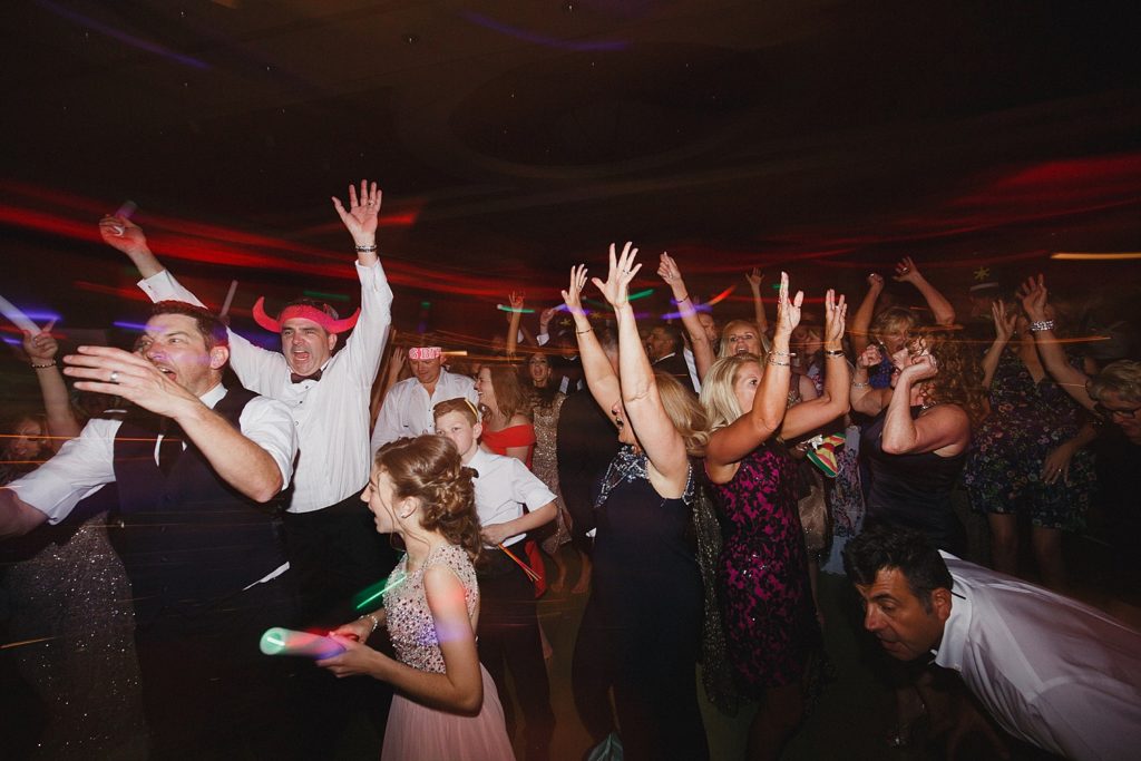 wedding guests dance with hands in the air in the omni ballroom